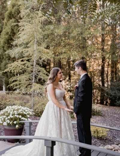 Couple holding hands standing on a wooden bridge